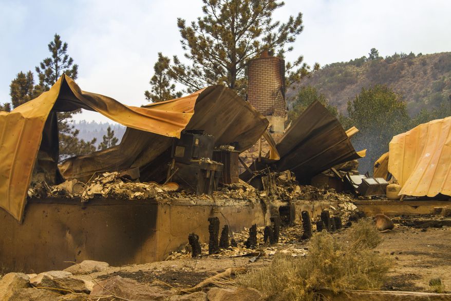 This Saturday, June 24, 2017, photo, shows a cabin burnt to the ground by a wildfire fire on the west side of Panguitch Lake, near Panguitch, Utah. Nearly 1,000 firefighters battled a Utah wildfire that grew Sunday morning that has prompted the evacuation of over a 1,000 people from hundreds of homes and cabins. (Jordan Allred/The Spectrum via AP)