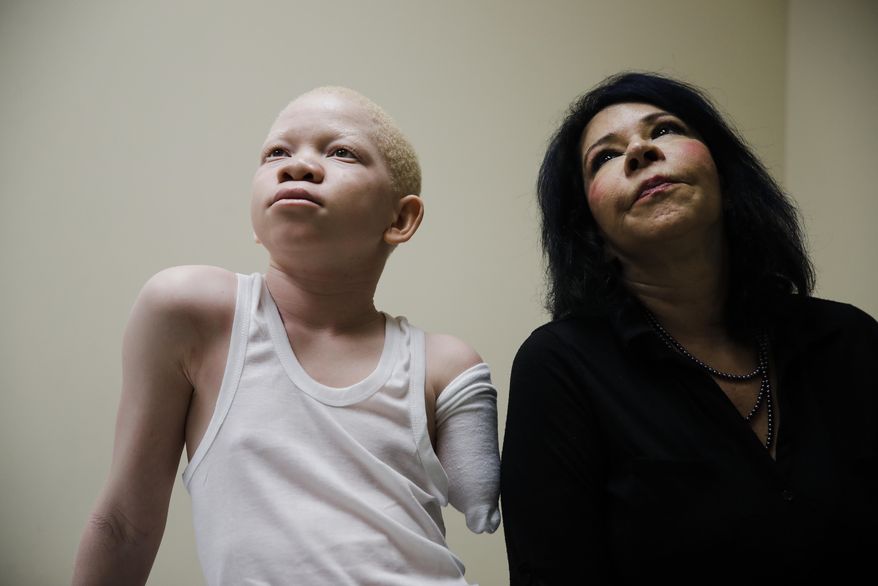 Mwigulu Matonange waits with Elissa Montanti, founder and director of the Global Medical Relief Fund during a prosthetic limb fitting at Shriners Hospital for Children in Philadelphia, Tuesday, May 30, 2017. (AP Photo/Matt Rourke)