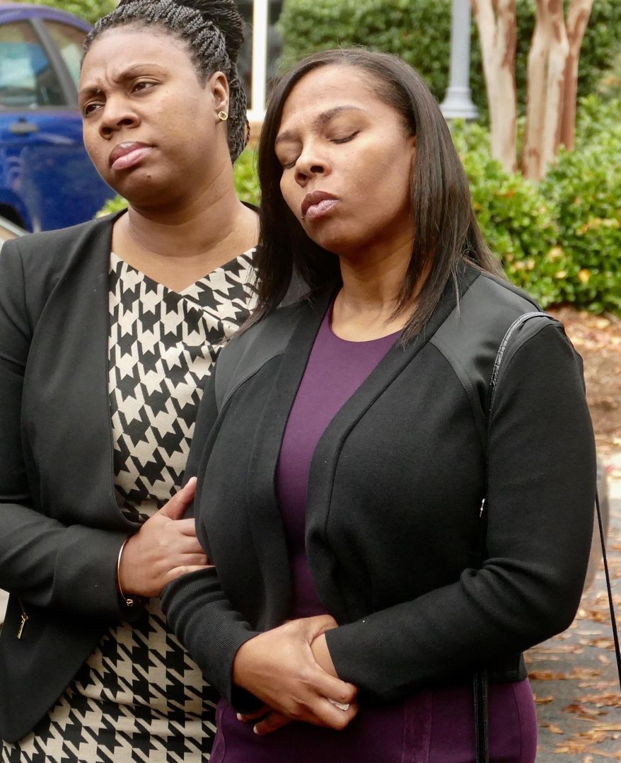 FILE- In this Nov. 30, 2016, file photo, the family of Keith Lamont Scott including his wife Rakeyia Scott, right, attend a news conference after finding out charges would not be filed against officer Brentley Vinson in the fatal shooting of her husband. A review board Tuesday, June 27, 2017, found "substantial evidence of error" in a North Carolina police department's decision that the fatal shooting of Keith Lamont Scott was justified and scheduled another hearing on the matter in August. (Davie Hinshaw/The Charlotte Observer via AP, File)
