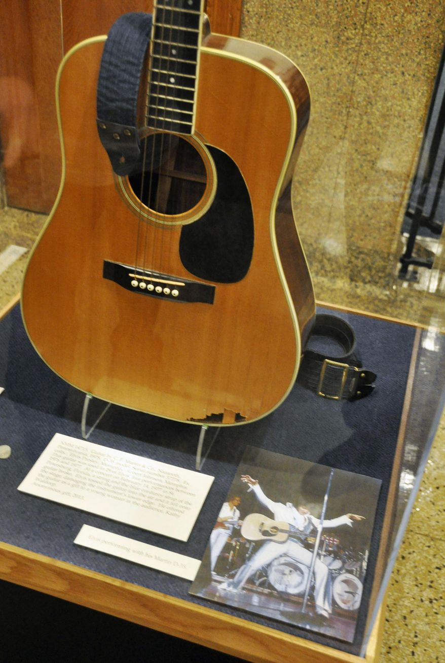 FILE - In this April 22, 2013, file photo, a slightly smashed acoustic guitar played by Elvis Presley during the final tour before his death in 1977 is displayed at the National Music Museum in Vermillion, S.D. Memorabilia collector Larry Moss, of Tennessee, is asking an appeals court to overturn a decision that awarded the guitar to the museum at the University of South Dakota. A federal judge ruled this year the museum could keep the guitar after Moss claimed he was the rightful owner. A three-judge panel from the 8th Circuit Court of Appeals will rule on the case. (AP Photo/Dirk Lammers, File)
