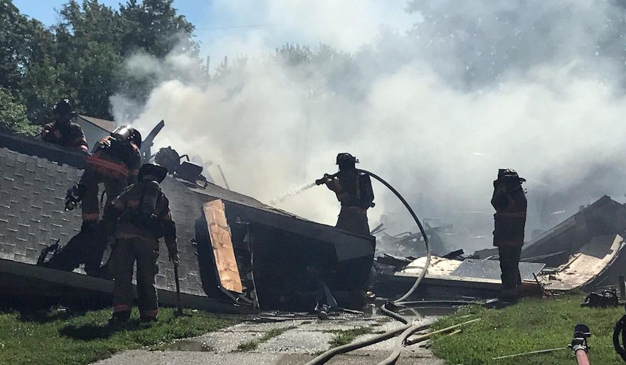 Firefighters work at the scene after an explosion and fire destroyed a home, Tuesday, June 27, 2017, in Evansville, Ind. Authorities say at least three people were injured. The cause of the explosion wasn't immediately known. (Sam Owens/Evansville Courier & Press via AP)