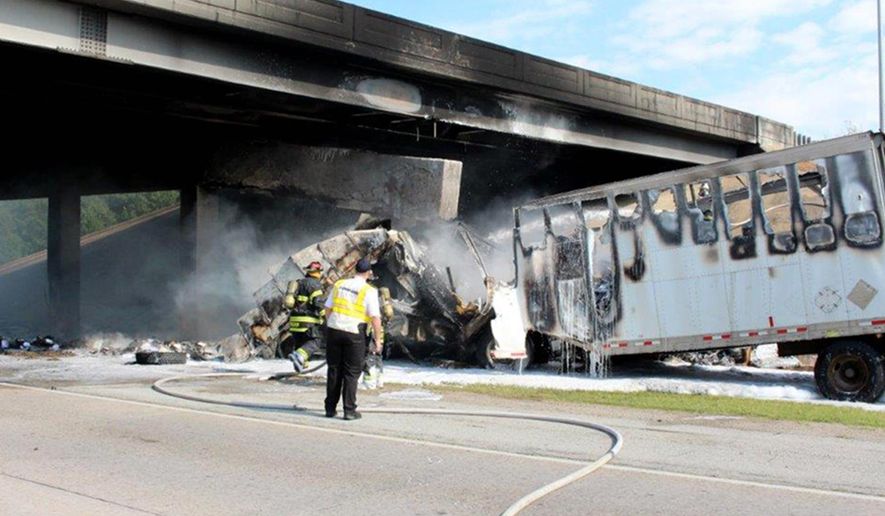 This photo provided by the Jonesboro Police Department shows emergency personnel at the scene Tuesday, June 27, 2017, where a tractor-trailer rig ran into a overpass on northbound Interstate 555 in Jonesboro, Ark. A police spokesman said the truck driver was killed in the accident. (Paul Holmes/Jonesboro Police Department via AP)