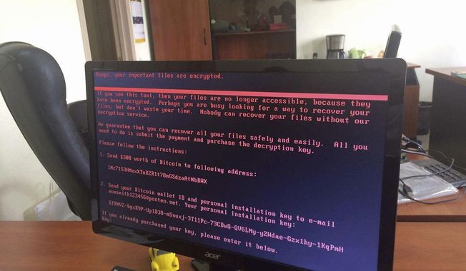 A computer screen cyberattack warning notice reportedly holding computer files to ransom, as part of a massive international cyberattack, at an office in Kiev, Ukraine, Tuesday June 27, 2017.    (Oleg Reshetnyak via AP)