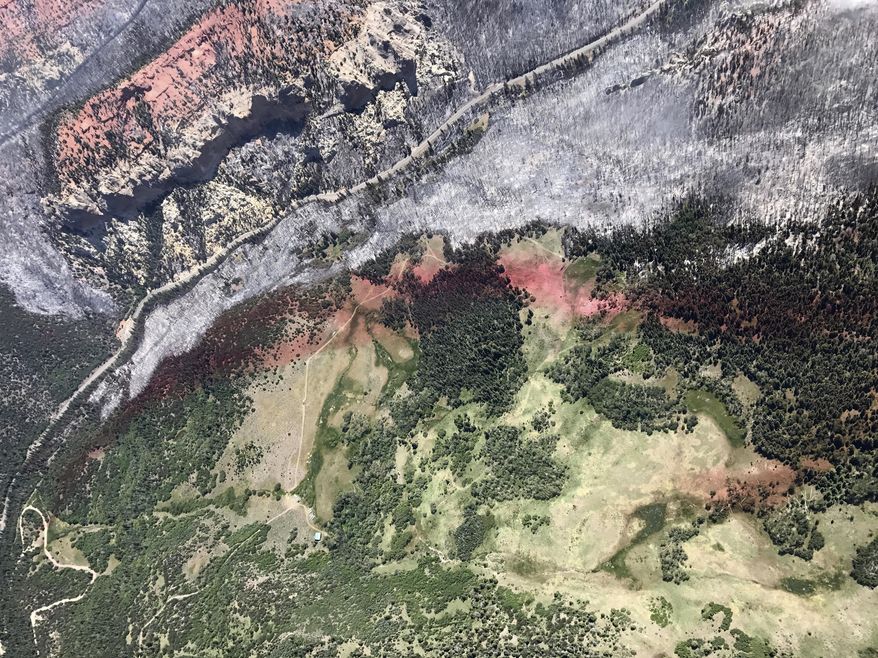 This Monday, June 27, 2017, taken by Justin Harding, shows slurry lines around burnout areas near Parowan, during a tour by Utah Lt. Gov. Spencer Cox, in southern Utah. The nation's largest wildfire has forced more than 1,500 people from their homes and cabins in a southern Utah mountain area home to a ski town and popular fishing lake. (Justin Harding/ State of Utah, Office of the Governor, via AP)
