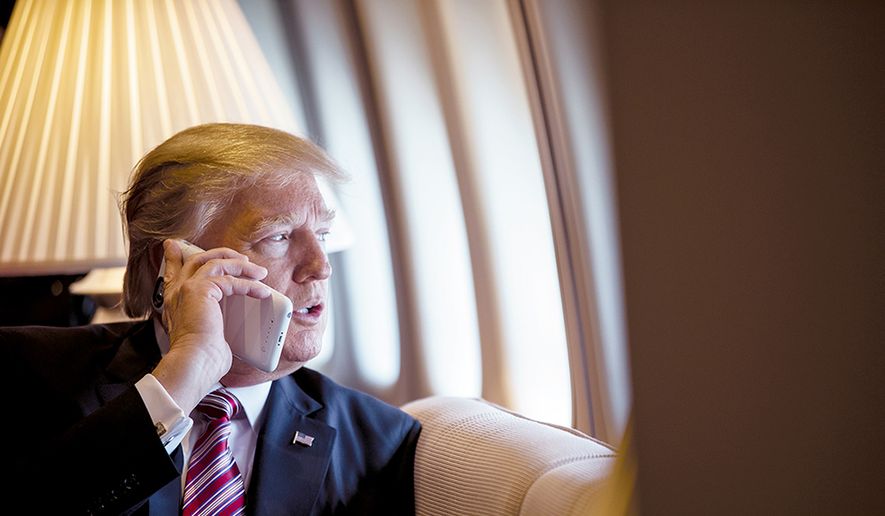 President Donald Trump talks on the phone aboard Air Force One during a flight to Philadelphia, Pennsylvania, to address a joint gathering of House and Senate Republicans, in this file photo from Thursday, January 26, 2017.  (Official White House Photo by Shealah Craighead) **FILE**