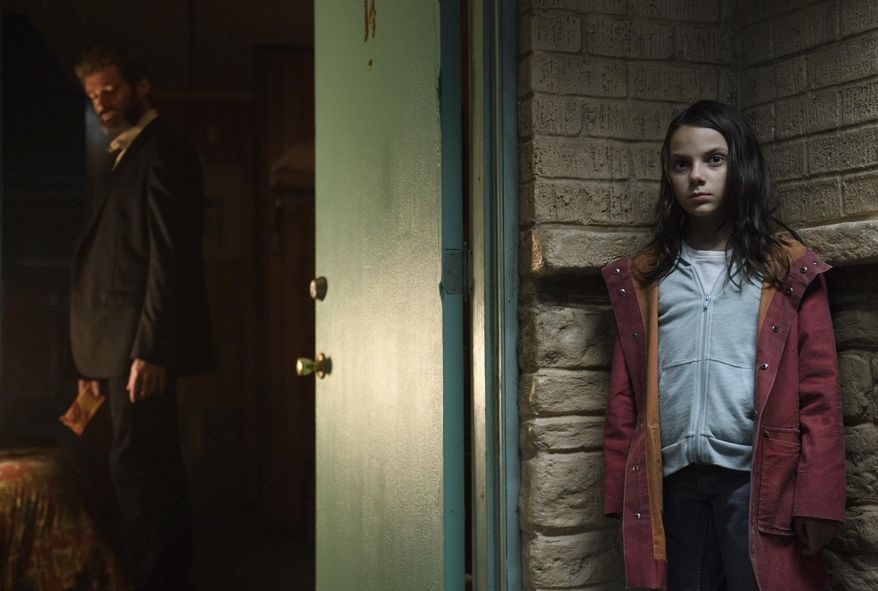This image released by Twentieth Century Fox shows Dafne Keen, right, and Hugh Jackman in a scene from "Logan." (Ben Rothstein/Twentieth Century Fox via AP)