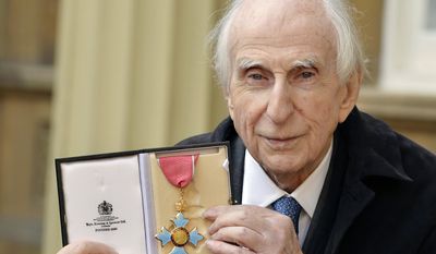 FILE - In this Oct. 27, 2015 file photo, Michael Bond, the creator of Paddington Bear, poses with his Commander of the Order of the British Empire (CBE). Publisher HarperCollins says Michael Bond, creator of globe-trotting teddy Paddington bear, died on Tuesday June 27, 2017, aged 91. (John Stillwell/PA via AP)