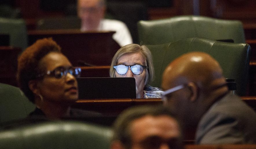 CORRECTS IDENTIFICATION TO BARBAR FLYNN CURRIE, NOT JIM DURKIN - Rep. Barbara Flynn Currie, D-Chicago, center, works on a laptop at her desk on the House floor Wednesday, June 28, 2017 at the Capitol in Springfield, Ill. The General Assembly is in its ninth day of a special session in an effort to agree on a budget deal before the end of the fiscal year on June 20. (Rich Saal/The State Journal-Register via AP)