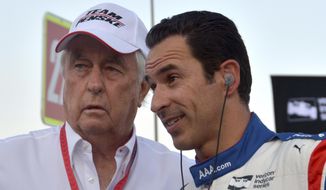 FILE - In this June 10, 2017, file photo, team owner Roger Penske, left, talks with driver Helio Castroneves, of Brazil, on pit road before an IndyCar auto race at Texas Motor Speedway in Fort Worth, Texas. Chemistry on and off the track has helped fuel Team Penske’s IndyCar success, with three-time Indianapolis 500 winner Helio Castroneves setting the tone. (AP Photo/Randy Holt, File)