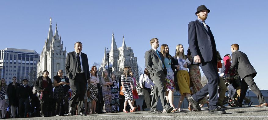 FILE - This April 2, 2016, file photo, Mormon women wear dresses on their way to the religion's twice-yearly conference in Salt Lake City. Church leaders announced Wednesday, June 28, 2017, that women who work at church headquarters in Salt Lake City can now wear pantsuits or dress slacks instead of only skirts or dresses. Men who work for the church will also now be allowed to remove their suit coats in hot weather. (AP Photo/Rick Bowmer, File)