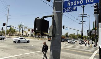 A pedestrian crosses a section of Rodeo Road that will be renamed Obama Boulevard in honor of former President Barack Obama, on Wednesday, June 28, 2017, in Los Angeles. The Los Angeles City Council has voted unanimously to name a street for former President Obama. The motion approved 14-0 Wednesday calls for the city engineer to begin the process of renaming several miles of Rodeo Road as Obama Boulevard. (AP Photo/Chris Pizzello)