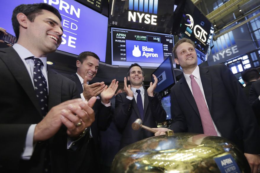Blue Apron CEO Matt Salzberg, right, with fellow company co-founders Ilia Papas, left, and Matt Wadiak, second from right, rings a ceremonial bell on the New York Stock Exchange floor as their IPO begins trading, Thursday, June 29, 2017. NYSE President Tom Farley is second from left. (AP Photo/Richard Drew) ** FILE **