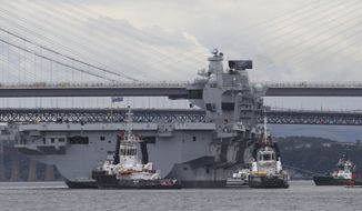 HMS Queen Elizabeth, one of two new aircraft carriers for the Royal Navy, is assisted by tugs on the Firth of Forth after leaving the Rosyth dockyard, Scotland, near Edinburgh to begin her sea worthiness trials, Monday June 26, 2017. Naval staff and contractors lined the deck of HMS Queen Elizabeth as the 280-metre, 65,000-tonne aircraft carrier moved in a three-hour operation. (Andrew Milligan/PA via AP)