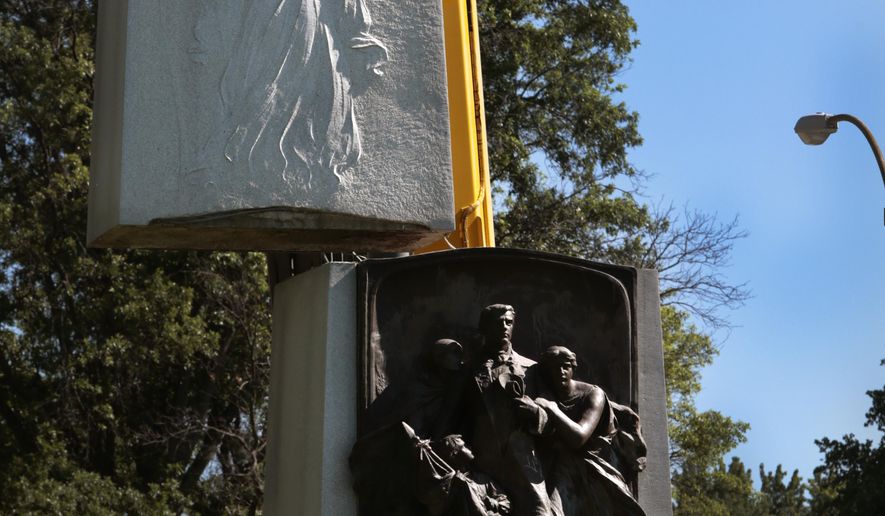 A crane removes the top section of the Confederate monument in Forest Park on Monday, June 26, 2017, in St. Louis. Crews on Monday began dismantling the divisive monument after the city and the Missouri Civil War Museum reached an agreement to have it moved. (Robert Cohen /St. Louis Post-Dispatch via AP)