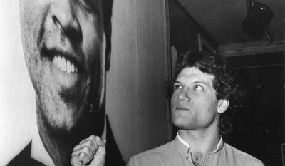 FILE - In this Feb. 24, 1983, file photo, Edmonton Oilers&#39; Dave Semenko makes a fist in front of a poster of boxer Muhammad Ali,  in Edmonton.  Former Edmonton Oilers tough guy Dave Semenko, who protected Wayne Gretzky in the 1980s, has died. He was 59. The Oilers say Semenko died after a short battle with cancer. A team spokesman said Semenko died in Edmonton. (Charlie Palmer/The Canadian Press via AP)