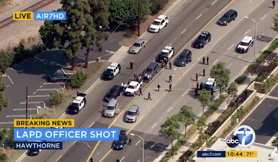 This image from video provided by KABC-TV shows the scene where a Los Angeles police officer was shot following the pursuit of a homicide suspect ending in El Segundo, Calif., on the border of neighboring Hawthorne, Thursday, June 29, 2017. Officials say the suspect was being pursued by a multi-agency task force but couldn't immediately provide additional details. Los Angeles Police Chief Charlie Beck said the officer was wounded in the hip and will recover. The suspect was also shot and wounded. (KABC-TV via AP)