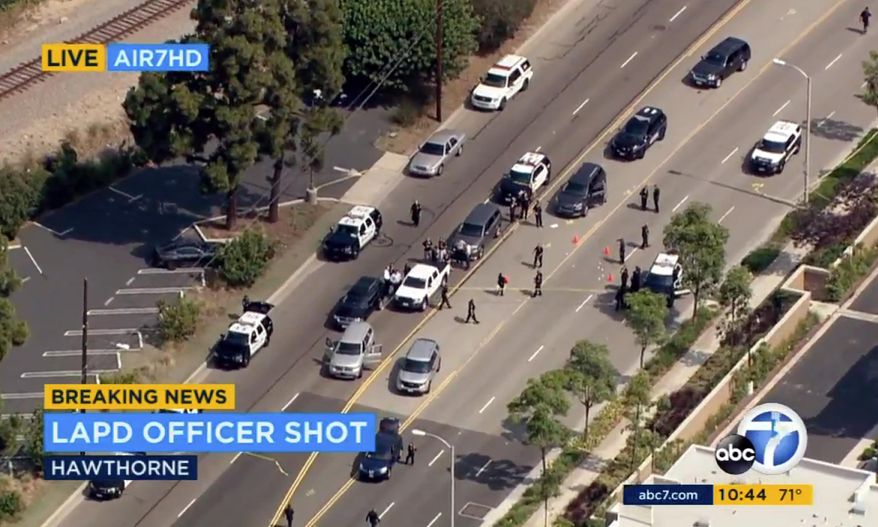 This image from video provided by KABC-TV shows the scene where a Los Angeles police officer was shot following the pursuit of a homicide suspect ending in El Segundo, Calif., on the border of neighboring Hawthorne, Thursday, June 29, 2017. Officials say the suspect was being pursued by a multi-agency task force but couldn't immediately provide additional details. Los Angeles Police Chief Charlie Beck said the officer was wounded in the hip and will recover. The suspect was also shot and wounded. (KABC-TV via AP)