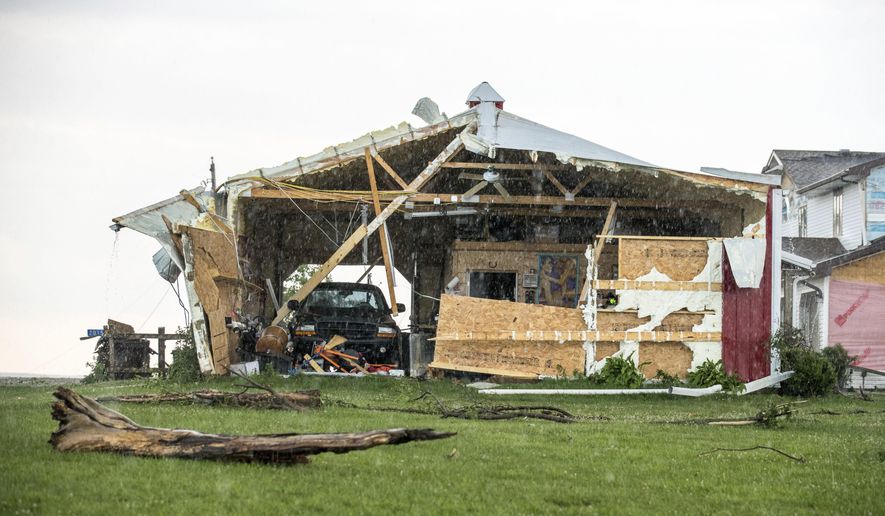 In this Wednesday, June 28, 2017 photo, a car sits in a garage, damaged after a tornado hit the property of Dee and Lynn Ossian in Farragut, Iowa. (Chris Machian/Omaha World-Herald via AP)