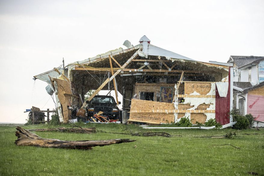 In this Wednesday, June 28, 2017 photo, a car sits in a garage, damaged after a tornado hit the property of Dee and Lynn Ossian in Farragut, Iowa. (Chris Machian/Omaha World-Herald via AP)