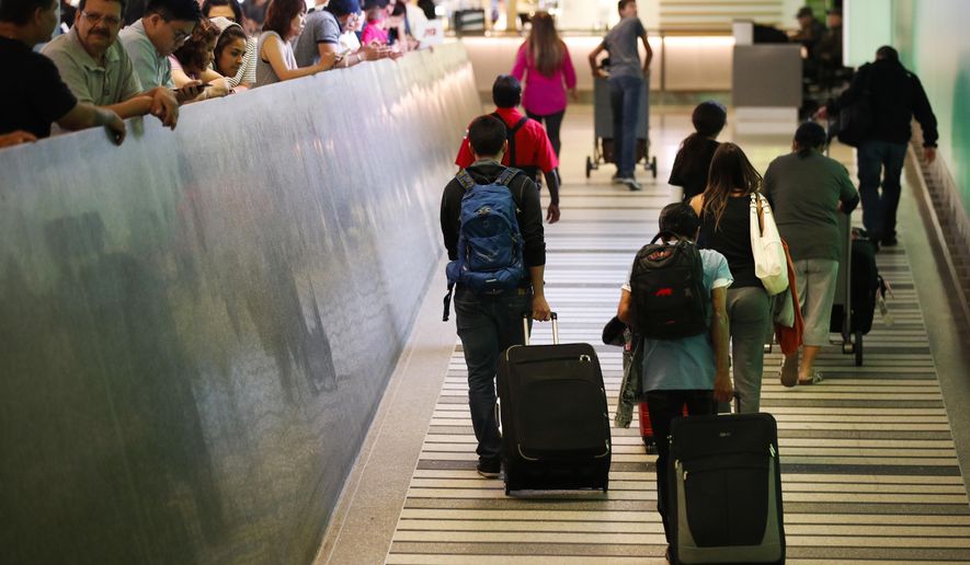 Travelers make their way up the arrival ramp at the Tom Bradley International Terminal at the Los Angeles International Airport Thursday, June 29, 2017, in Los Angeles. After months of wrangling, tighter restrictions on travel to the U.S. from six mostly Muslim nations take effect Thursday evening after the Supreme Court gave its go-ahead for a limited version of President Donald Trump's plans for a ban. (AP Photo/Jae C. Hong)