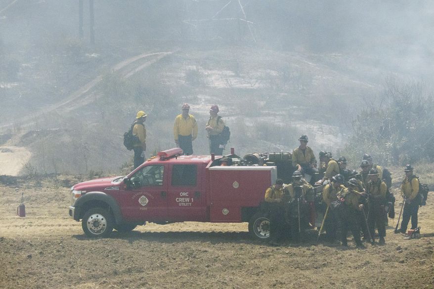 Firefighters keep an eye on the burning hillsides after setting back fires in San Clemente, Calif., Thursday, June 29, 2017. U.S. Sen. Dianne Feinstein says California's wildfire season could be more severe than last year, with nearly 30,000 acres already burned. (Ken Steinhardt/The Orange County Register via AP)
