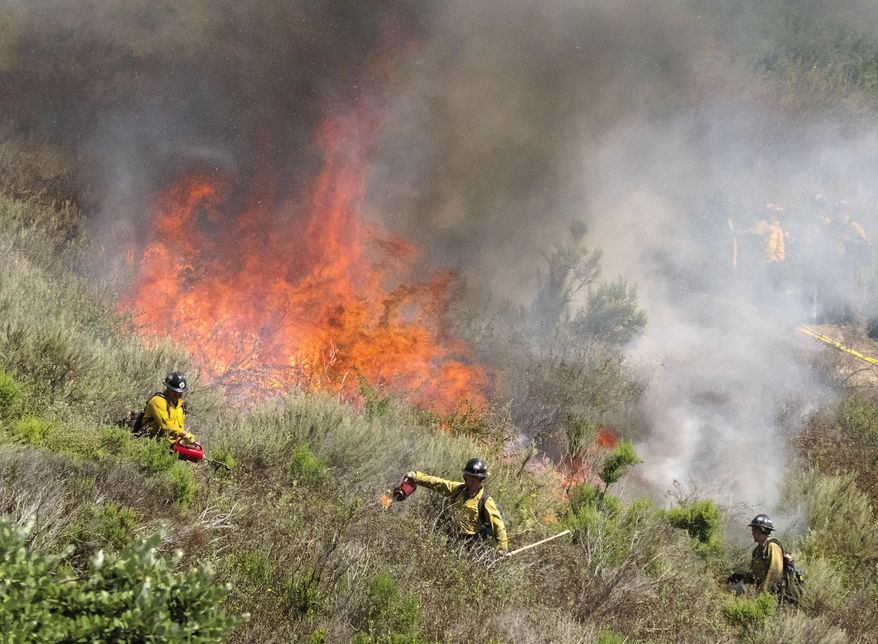 Firefighters set back fires as they work to put out a brush fire in San Clemente, Calif., Thursday, June 29, 2017. U.S. Sen. Dianne Feinstein says California's wildfire season could be more severe than last year, with nearly 30,000 acres already burned. (Ken Steinhardt/The Orange County Register via AP)