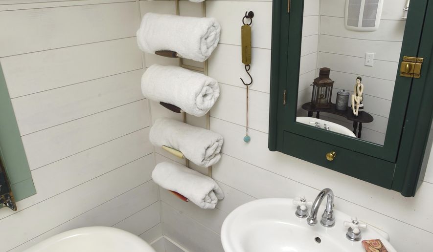 This Monday, June 19, 2017 photo shows the bathroom with no space wasted in the small cottage that Mary McGuigan and John Walden built in the Florida panhandle community of Seagrove Beach. The bathroom has full plumbing with a sink, toilet and restored claw-foot tub. (Devon Ravine/Northwest Florida Daily News via AP)