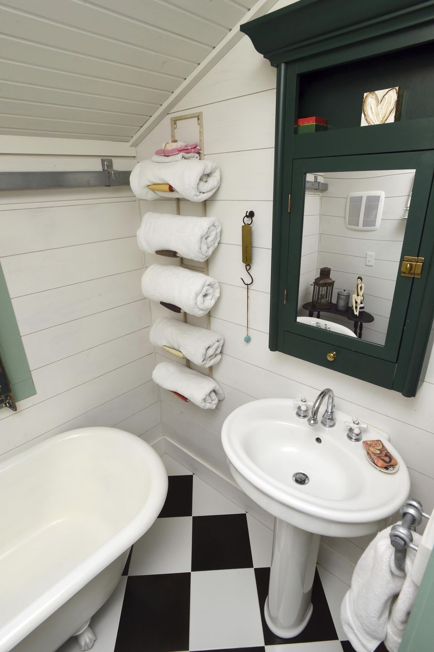 This Monday, June 19, 2017 photo shows the bathroom with no space wasted in the small cottage that Mary McGuigan and John Walden built in the Florida panhandle community of Seagrove Beach. The bathroom has full plumbing with a sink, toilet and restored claw-foot tub. (Devon Ravine/Northwest Florida Daily News via AP)