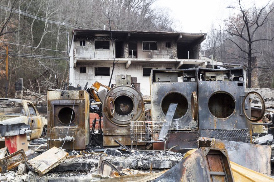 FILE - In this Dec. 9, 2016, file photo, the remains of laundry machines sit on the site of a burned inn near downtown Gatlinburg, Tenn. District Attorney General Jimmy Dunn said Friday, June 30, 2017, that two juveniles would no longer face charges for the wildfire because there were other contributing factors, such as strong winds and down power lines, that contributed to the seriousness of the blaze that killed 14 people. (AP Photo/Erik Schelzig, File)