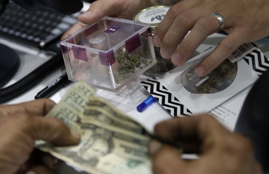 A person buys marijuana at the Essence cannabis dispensary, Saturday, July 1, 2017, in Las Vegas. Nevada dispensaries were legally allowed to sell recreational marijuana starting at 12:01 a.m. Saturday. (AP Photo/John Locher)