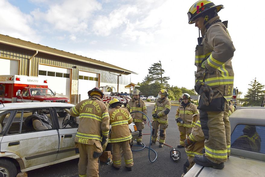 In this June 21, 2017 photo, Cannon Beach volunteer firefighter Shaunna White, right, watches over a vehicle extrication training exercise in Cannon Beach, Ore. For some couples, romance is a dozen red roses and a box of chocolates. But for Shaunna White, romance looks more like driving a big, red fire truck. Shaunna and her husband, TJ White, to whom she’s been married for six years, both serve as volunteers for Cannon Beach Fire and Rescue, and have done so together for the past three years. (Colin Murphey/Daily Astorian via AP)