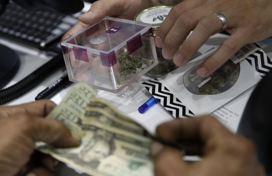 A person buys marijuana at the Essence cannabis dispensary, Saturday, July 1, 2017, in Las Vegas. Nevada dispensaries were legally allowed to sell recreational marijuana starting at 12:01 a.m. Saturday. (AP Photo/John Locher)