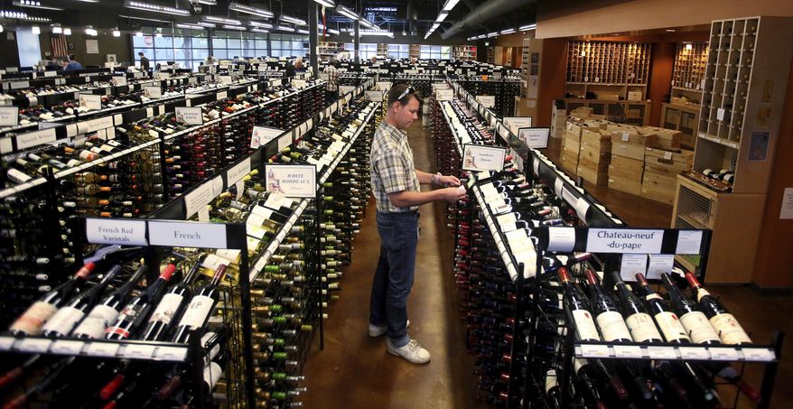 A worker at a state liquor store changes prices on wine, liquor and higher-alcohol beer, after closing to the public Friday, June 30, 2017, near downtown Salt Lake City. Higher liquor prices and other changes under a broad new Utah liquor law will take effect Saturday, along with a highway funding bill and a test program allowing people convicted of drunken driving to avoid having their driver's license suspended. (AP Photo/Rick Bowmer)
