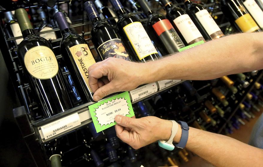 A worker at a state liquor store changes prices on wine, liquor and higher-alcohol beer, after closing to the public Friday, June 30, 2017, near downtown Salt Lake City. Higher liquor prices and other changes under a broad new Utah liquor law will take effect Saturday, along with a highway funding bill and a test program allowing people convicted of drunken driving to avoid having their driver's license suspended. (AP Photo/Rick Bowmer) ** FILE **