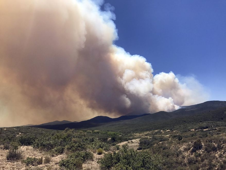 FILE - In this Tuesday, June 27, 2017, file photo, smoke billows from a wildfire locally called Goodwin Fire, near Prescott, Ariz. Gene Alan Carpenter, 54, who is accused of flying a drone over a major Arizona wildfire has been arrested, with authorities saying he interrupted firefighting efforts on a blaze that has forced thousands of people from their homes. The Yavapai County Sheriff's Office said Saturday, July 1, 2017, that Carpenter of Prescott Valley was in custody on charges of endangerment and unlawful operation of an unmanned aircraft. (Les Stukenberg/The Daily Courier via AP, File)