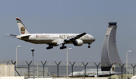 FILE - In this May 4, 2014 file photo, an Etihad Airways plane prepares to land at the Abu Dhabi airport in the United Arab Emirates. The capital of the United Arab Emirates became the first city to find itself exempt from a U.S. ban on laptop computers being in airplane cabins, the country’s flag carrier said Sunday. (AP Photo/Kamran Jebreili, File)