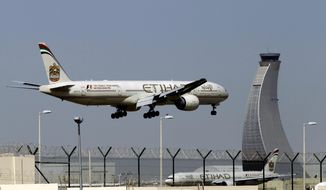 FILE - In this May 4, 2014 file photo, an Etihad Airways plane prepares to land at the Abu Dhabi airport in the United Arab Emirates. The capital of the United Arab Emirates became the first city to find itself exempt from a U.S. ban on laptop computers being in airplane cabins, the country’s flag carrier said Sunday. (AP Photo/Kamran Jebreili, File)