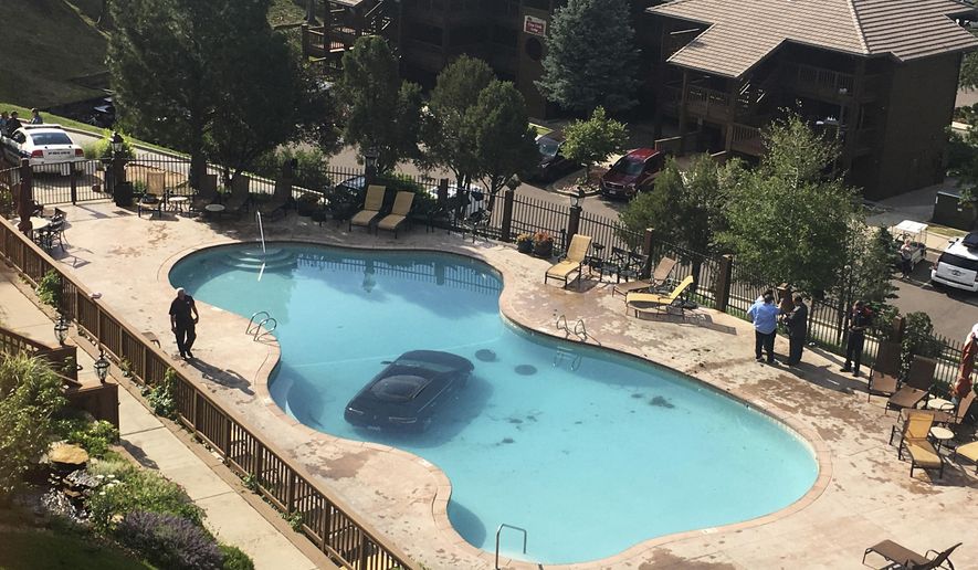 In this photo provided by KKTV 11 a car sits in a pool after a woman escaped injury when she hit the gas pedal instead of the brakes and ended up in the pool at the Cheyenne Mountain Resort, in Colorado Springs, Colo., on Monday morning, July 3, 2017. (Kyla Galer/KKTV 11 via AP)