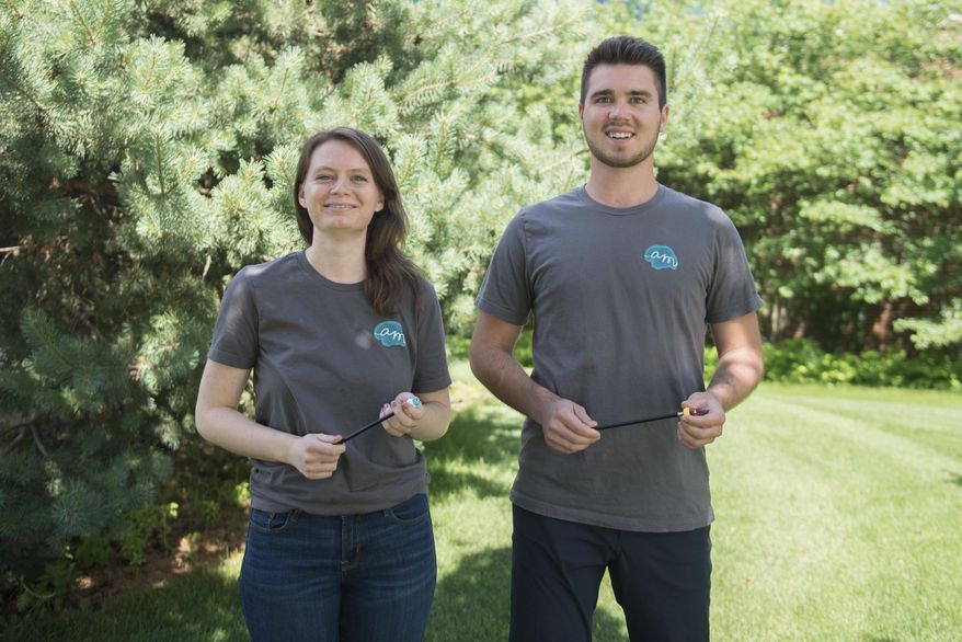 ADVANCE FOR USE MONDAY, JULY 3 - In this June 20, 2017 photo, Anna Wetmore, left,and Jake Scholz pose outside Carlson School of Management with a silent fidget devices in hand in Minneapolis. (Easton Green/The Minnesota Daily via AP)