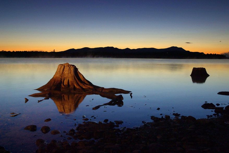 FILE - In this Sept. 5, 2001, file photo, the first light of dawn silhouettes the Katahdin Range east of Chesuncook Lake in Township 3, Range 13, Maine. (AP Photo/Robert F. Bukaty, File)