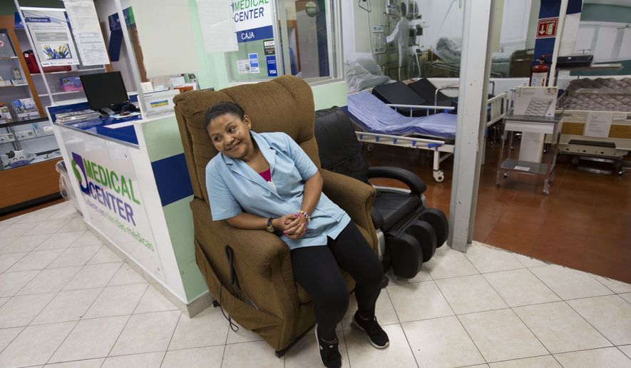 In this June 27, 2017 photo, Honduran refugee Laura Maria Cruz Martinez sits in a display chair as she waits for customers at the medical supplies store where she works in Mexico City. About five months after first applying for refugee status at Mexico&#x27;s southern border, Martinez&#x27;s family moved to Mexico City with the help of the United Nations refugee commission and Cruz found a job as a store clerk near downtown. (AP Photo/Rebecca Blackwell)