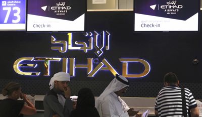 Passengers check into a flight at Abu Dhabi International Airport in Abu Dhabi, United Arab Emirates, Tuesday, July 4, 2017. Abu Dhabi&#39;s airport is the first among Mideast airports targeted by a U.S. ban on laptops in airplane cabins to be exempt from the list. (AP Photo/Jon Gambrell)