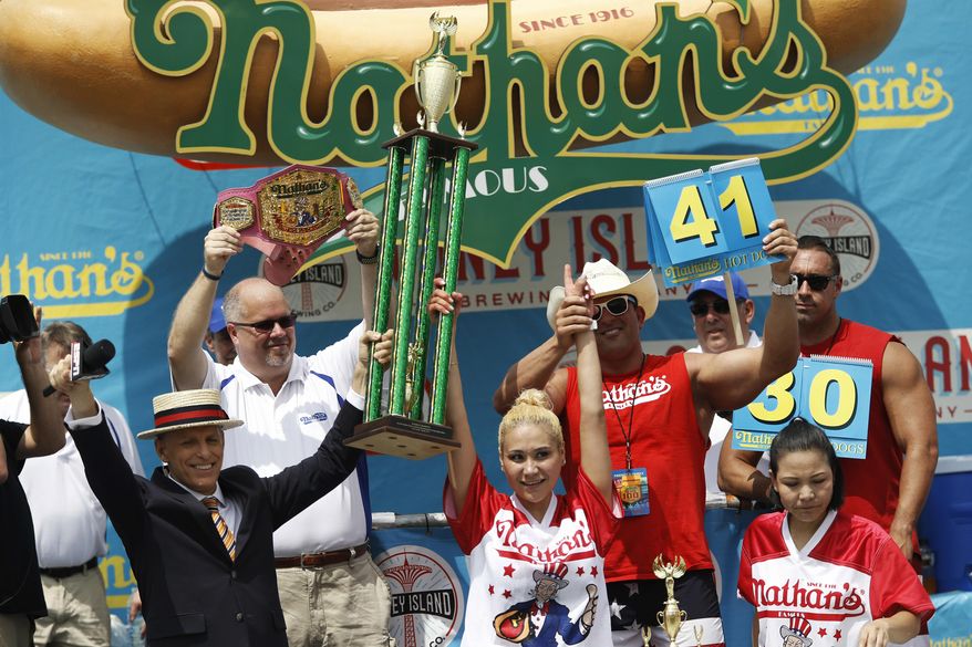 Miki Sudo grabs her fourth Nathan&#39;s Famous Hotdog eating contest win in the women&#39;s division on Tuesday, July 4, 2017, in the Brooklyn borough of New York. Sudo won after eating 41 hotdogs and buns. (AP Photo/Michael Noble Jr.)