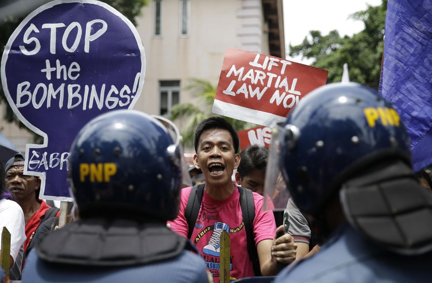 An activist shouts slogans denouncing the martial law in Mindanao as they hold a rally in front of the Supreme Court in Manila, Philippines on Tuesday, July 4, 2017. The Philippine Supreme Court has upheld President Rodrigo Duterte's declaration of martial law in the southern third of the country, dismissing petitions to nullify it.(AP Photo/Aaron Favila)