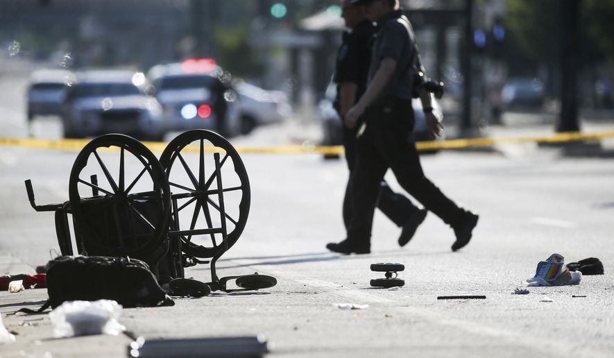 A wheelchair, shoes and other items lay in the street at the scene of an accident at the intersection of 200 South and 400 West Streets in Salt Lake City on Tuesday, July 4, 2017. Police say a car drove onto the sidewalk. (Spenser Heaps/The Deseret News via AP)