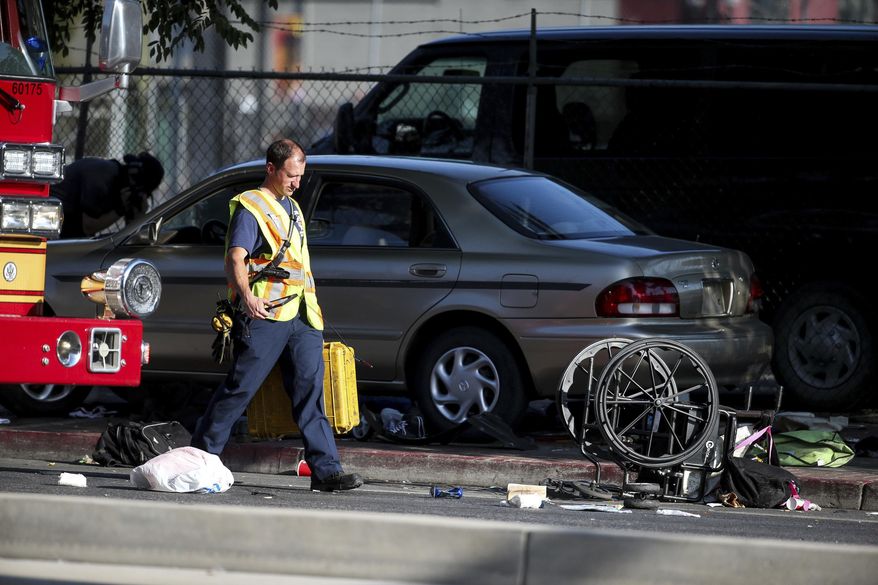 A wheelchair, shoes and other items lay in the street as officials work at the scene of an accident at the intersection of 200 South and 400 West Streets in Salt Lake City on Tuesday, July 4, 2017. Police say a car drove onto the sidewalk. (Spenser Heaps/The Deseret News via AP)
