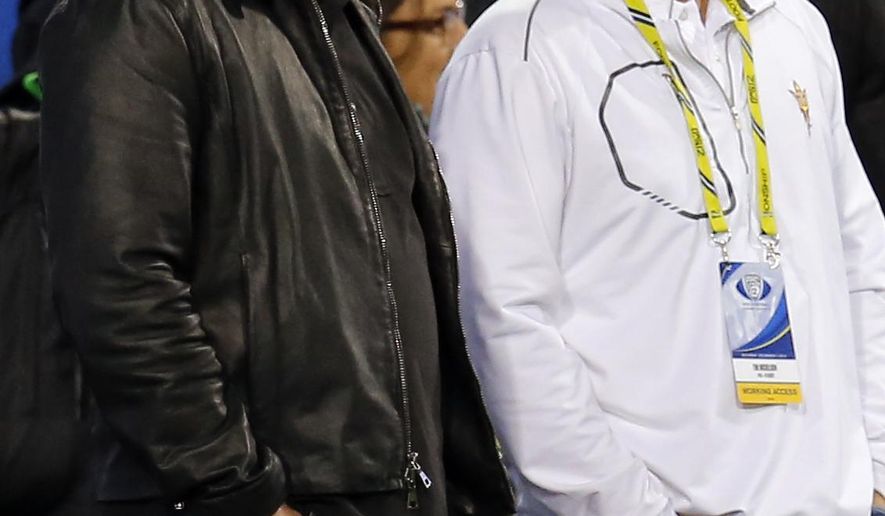 FILE - In this Dec. 7, 2013, file photo, PGA golfer Phil Mickelson, left, and his brother, Tim Mickelson, watch from the sidelines during the first half of the NCAA Pac-12 Championship football game between Arizona State and Stanford, in Tempe, Ariz. Phil Mickelson heads into the next phase of his career with a new caddie on a course marking its comeback from devastating floods in West Virginia. Mickelson will have brother Tim Mickelson on his bag starting Thursday, July 6, 2017, at the Greenbrier Classic in his first tournament since parting ways with his caddie of 25 years, Jim "Bones" Mackay. (AP Photo/Matt York, File)