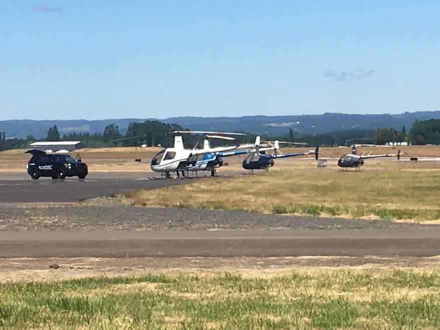Police respond to an attempted helicopter hijacking on Monday, July 3, 2017 at the Hillsboro Airport in Oregon. The suspect was fatally shot by officers shortly after attempting to take control of a helicopter from an instructor and flight student. (Olivia Dimmer/The Oregonian via AP)