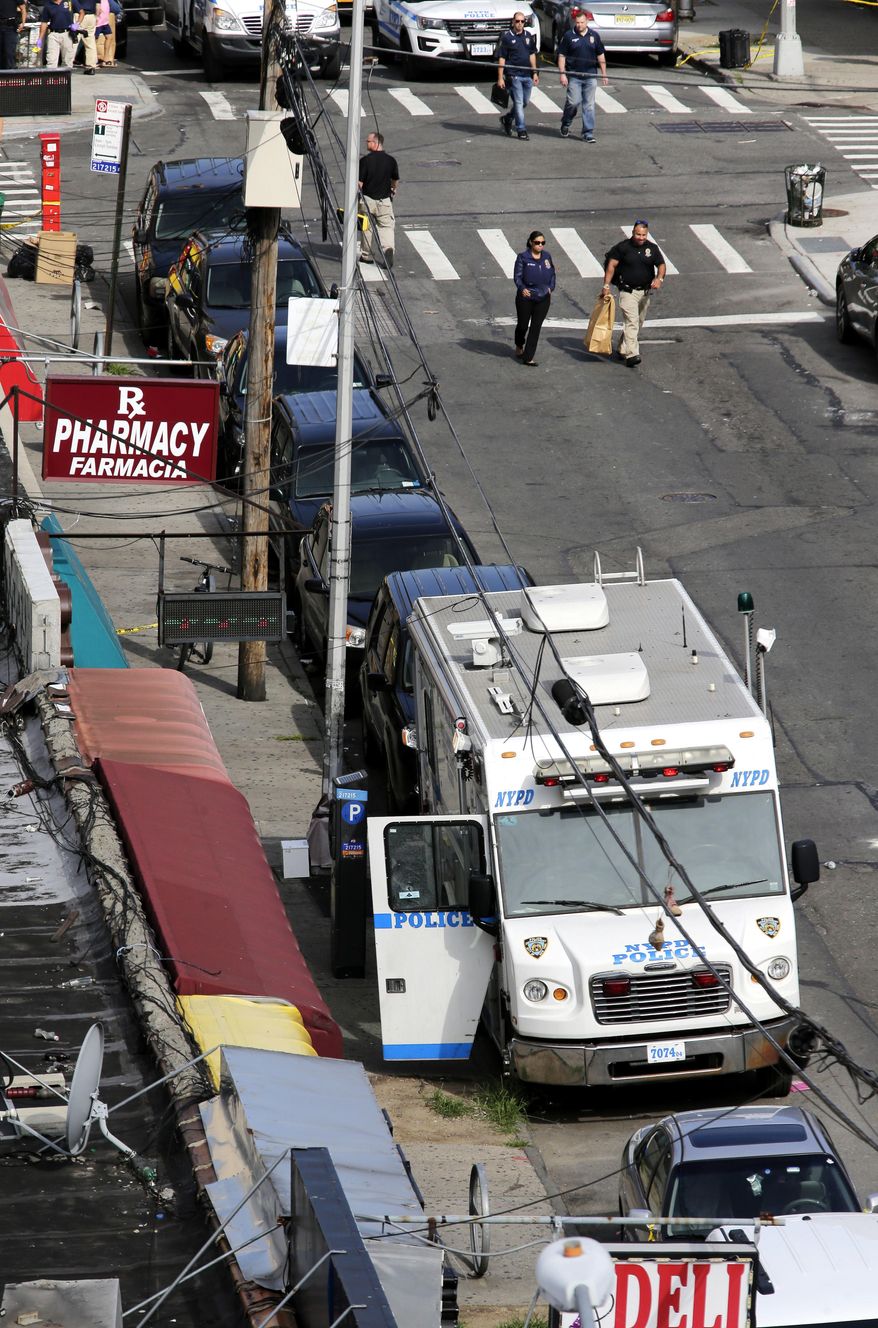 Emergency personnel work near the scene where a police officer was fatally shot in the Bronx section of New York, Wednesday, July 5, 2017. The officer was ambushed inside her command post RV by an ex-convict, authorities said. He was later killed after pulling a gun on police. (AP Photo/Seth Wenig)