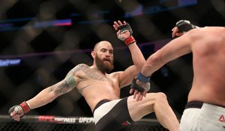FILE -  In this Jan. 17, 2016, file photo, Travis Browne, left, fights against Matt Mitrione in their mixed martial arts bout at UFC Fight Night 81, in Boston. Travis Browne&#39;s relationship with Ronda Rousey blossomed while his mixed martial arts career fell apart with three straight losses. Browne says his fiancee&#39;s support is the main reason he&#39;s still in the cage and preparing for a crucial fight Saturday at UFC 213. (AP Photo/Gregory Payan, File)